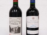 deux bouteilles de vin rouge posées l'une à côté de l'autre sur une surface blanche