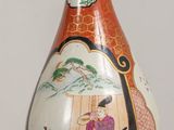 a vase with a painting on it sitting on a table