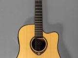 a small acoustic guitar hanging on a wall