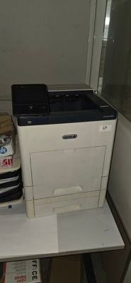 a printer sitting on top of a desk next to a stack of boxes
