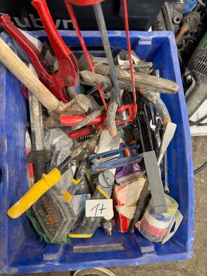 un bac bleu rempli d'outils posé par terre