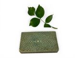 a small green wallet with a leaf on top of it