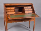 an old wooden desk with a green top and drawers