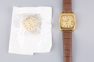 une montre posée à côté d'une feuille de papier