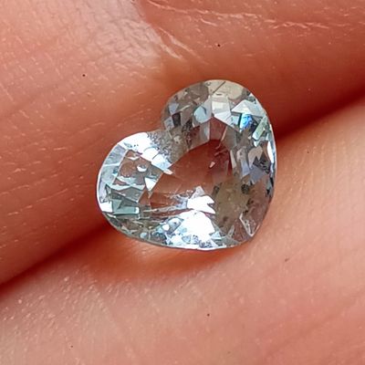 quelqu'un tient un diamant en forme de cœur dans la main