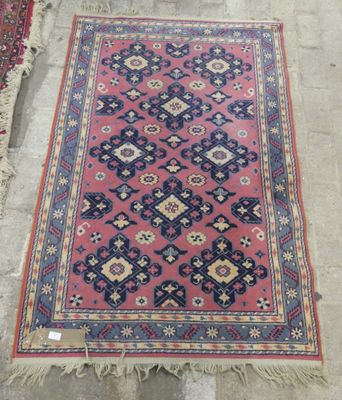 a pink rug with blue and red designs on it