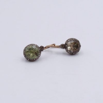a close up of a pair of earrings on a white surface