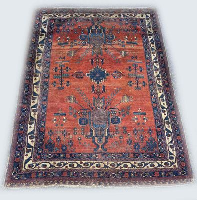 an antique rug with a red and blue design on a white background