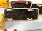 two old toy cars sitting on a table next to a box of candy