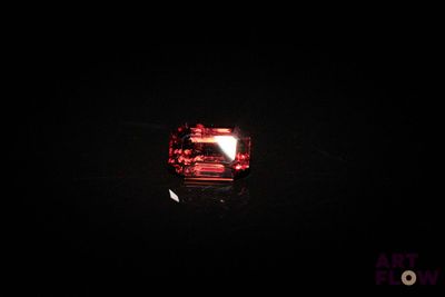 une image montrant un gros plan d'un diamant rouge dans l'obscurité