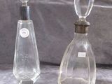 two bottles of perfume sitting next to each other on a table