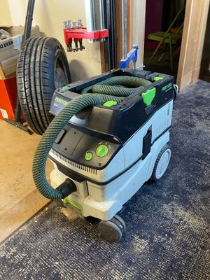 une photo d'un aspirateur vert et noir posé par terre