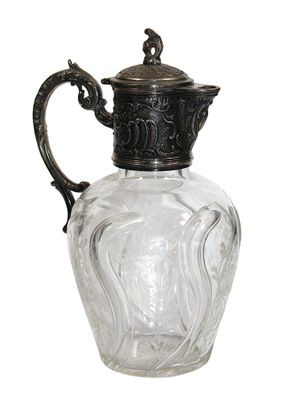 a glass pitcher with a metal handle on a white background