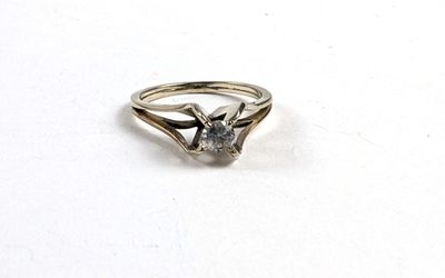une image d'une bague en diamant sur une surface blanche