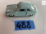 une petite voiture posée à côté d'une feuille de papier