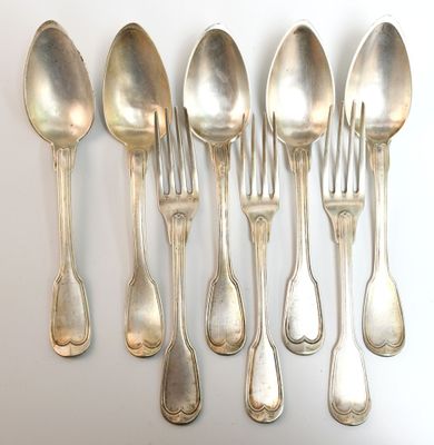 six cuillères et six cuillères posées sur une surface blanche