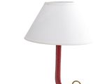 la lampe est rouge et est surmontée d'un abat-jour blanc
