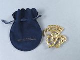 une image représentant une pochette en velours bleu ornée d'une broche en or et d'une broche en or