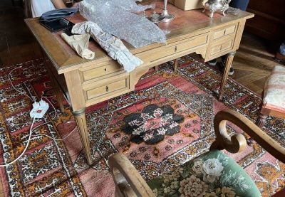 une femme assise à une table sur laquelle se trouvent de nombreux objets