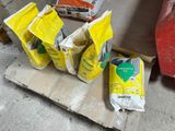 several bags of cement sitting on top of a pallet next to a red fire hydrant