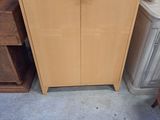 une armoire en bois sur laquelle est accrochée une pancarte, dans une pièce