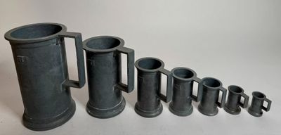 a group of black vases sitting next to each other on a table
