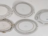 four white plates on a white table with a white background