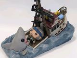 a figurine of a man in a boat with a shark