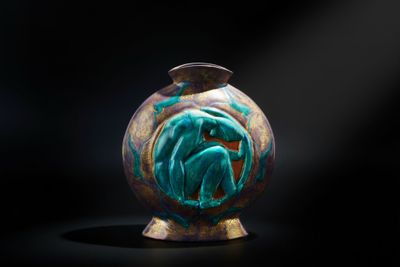 un vase orné d'un motif vert et doré