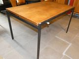 une table en bois avec des pieds en métal et un plateau en bois