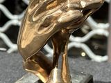a gold statue of a hand holding a baseball bat