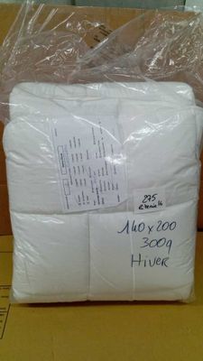 two white pillows are wrapped in plastic bags on top of a cardboard box