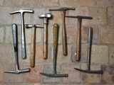 de nombreux types de marteaux différents disposés sur un mur de briques