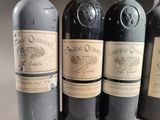 several bottles of wine are lined up on a table