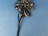 an image of a silver flower brooch on a blue background