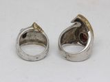 pair of silver and gold rings with garnets on them