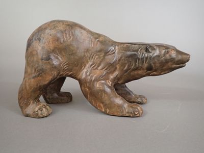 statue of a brown bear on a gray surface