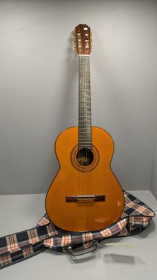une guitare posée sur une table à côté d'une cravate