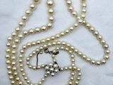 un gros plan sur un collier orné de perles et d'une croix