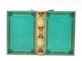 a green book with gold trim and a red rose on the cover