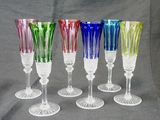 six multicolored wine glasses are lined up in a row