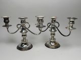 two silver candelabs are sitting on a white surface