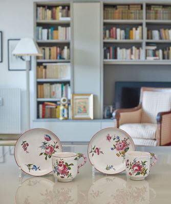 a table with a bowl, plate, and cups on it