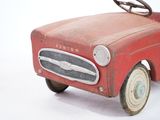 a red toy car that is sitting on a white surface