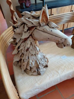 a horse made out of drift wood sitting on a cushion