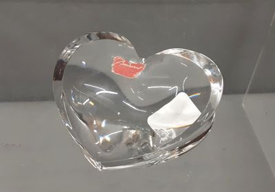 a glass heart shaped object on display in a glass case