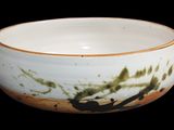 a white bowl with a brown rim on a black background