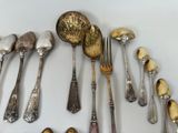 a lot of silver spoons and spoons on the table