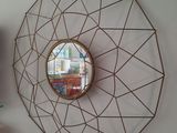 un miroir accroché au mur à côté d'une étagère