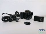 a camera with a microphone attached to it next to a charger